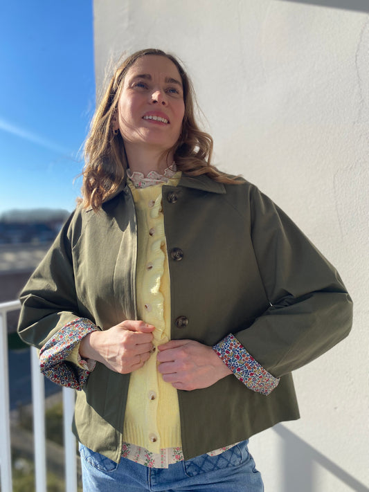 Femme portant la veste Léonie kaki avec manches retroussées révélant un motif fleuri liberty.